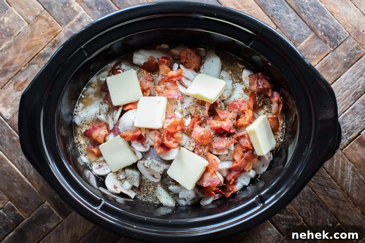 Slow-Cooked Venison Roast with Savory Mushroom Gravy 6 venison roast in slow cooker with bacon, onion, butter and onion on top, before cooking.