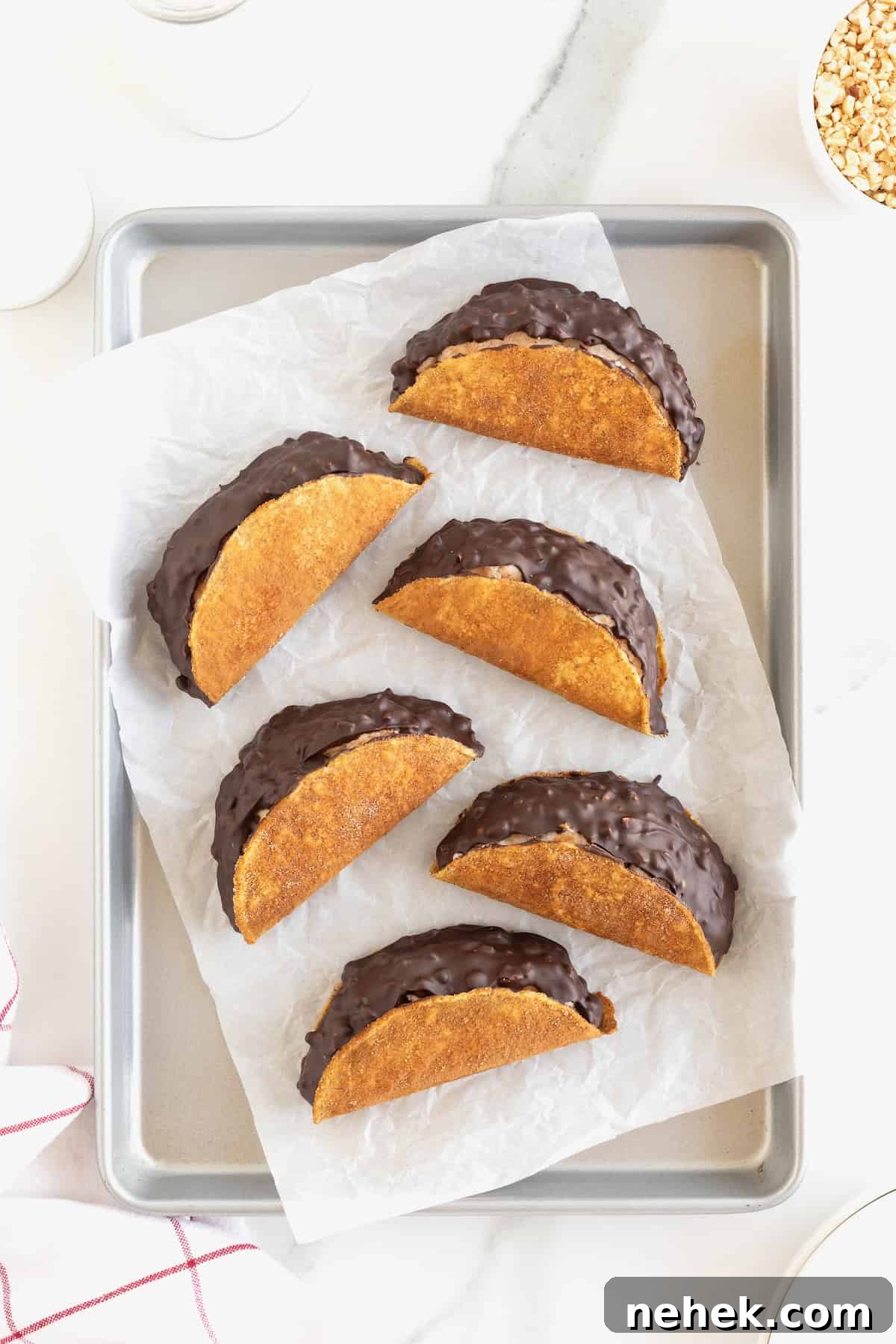 How to Make Homemade Chocolate Tacos: Step-by-Step Recipe 11 Six chaco tacos on a parchment lined aluminum baking sheet.