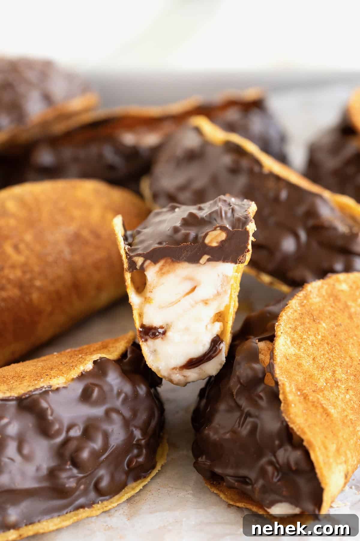 How to Make Homemade Chocolate Tacos: Step-by-Step Recipe 4 A pile of chaco tacos. The top chaco taco is cut in half to reveal the fudge swirled ice cream.
