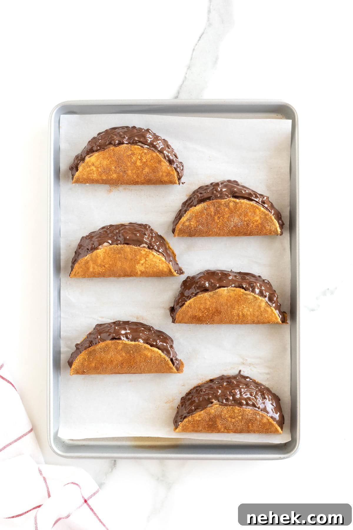 How to Make Homemade Chocolate Tacos: Step-by-Step Recipe 10 Six choco tacos on a parchment lined aluminum baking sheet.