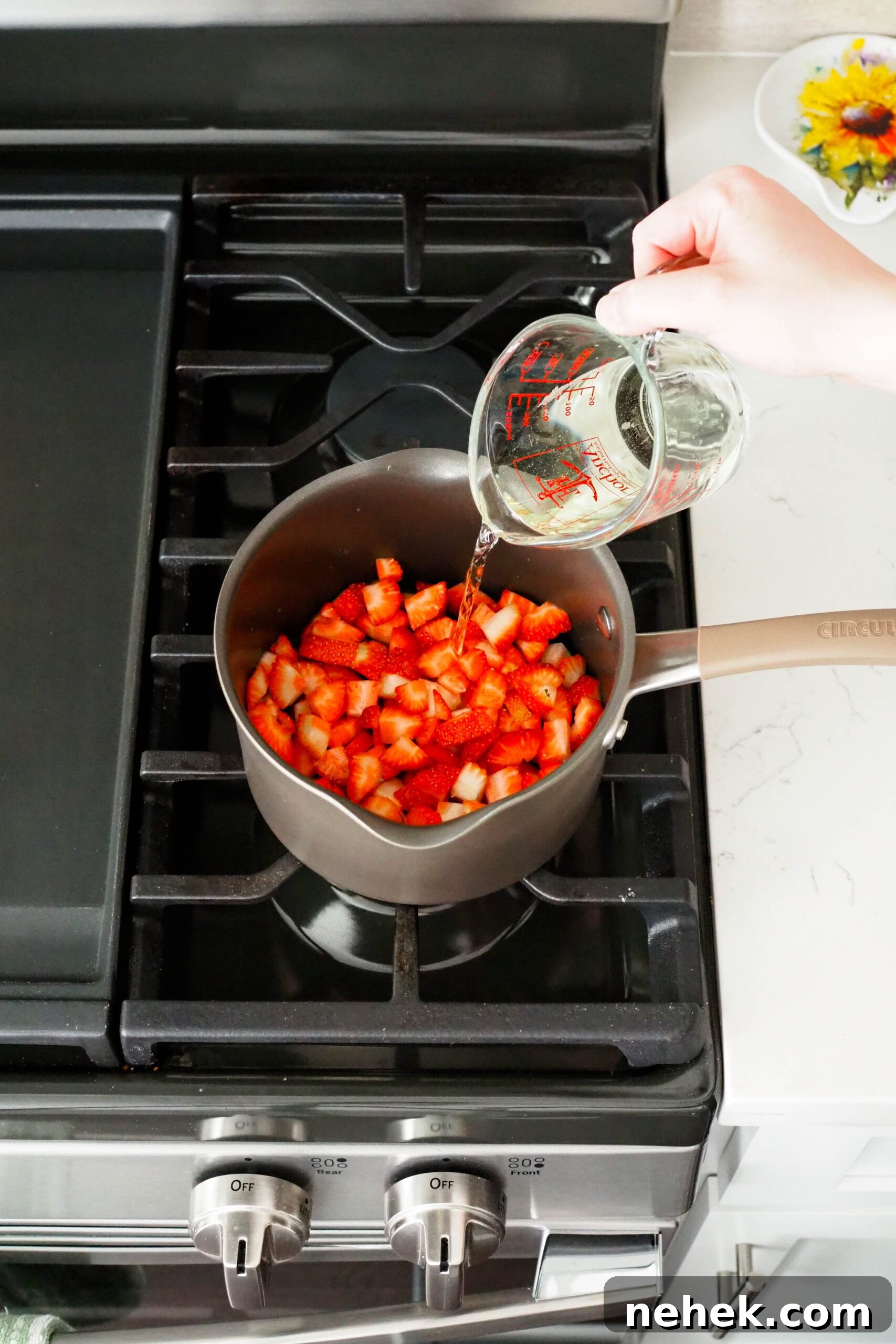 Champagne is poured into strawberries in a medium saucepan.