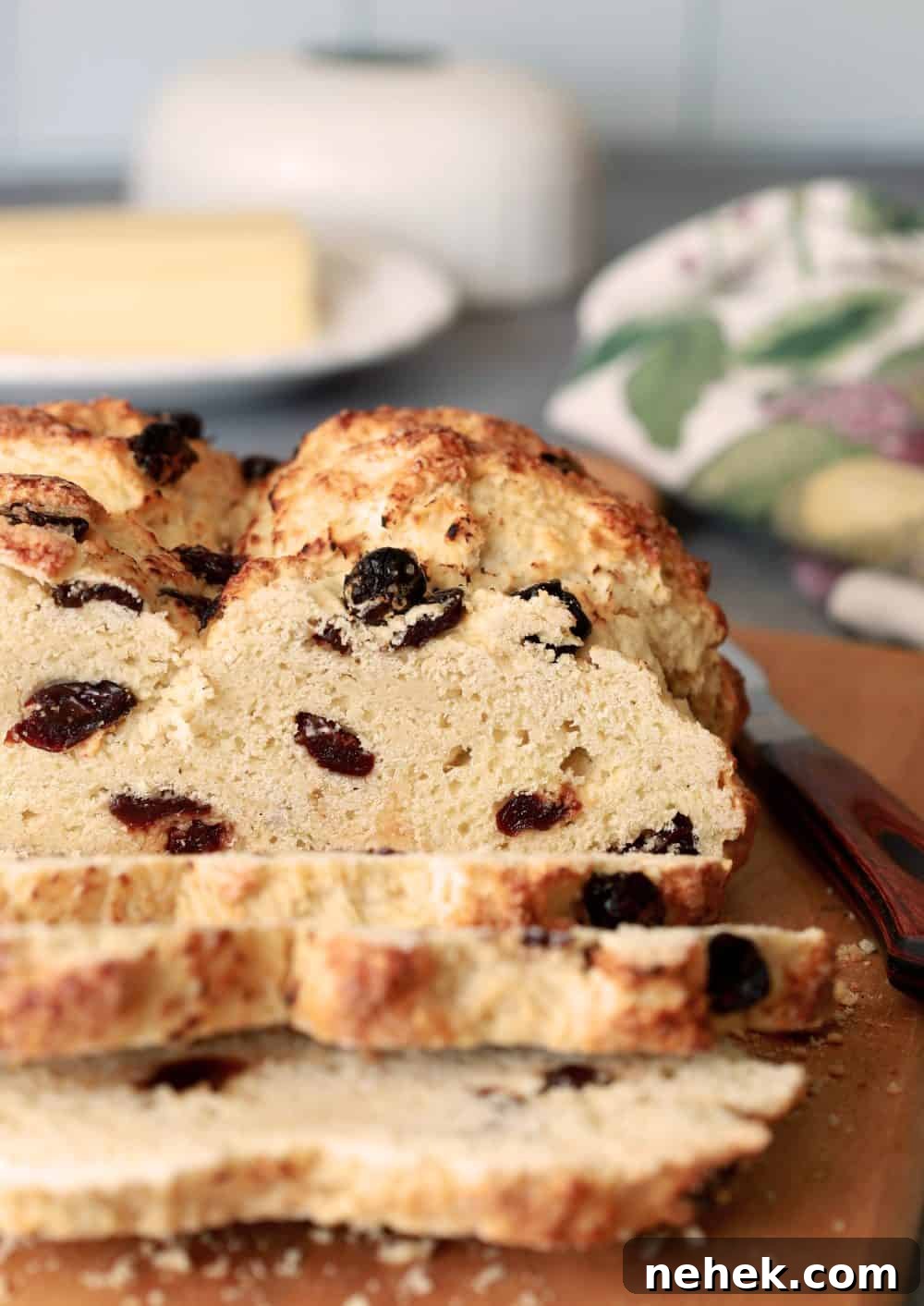 Slices of Irish Soda Bread on a cutting board with butter in background.
