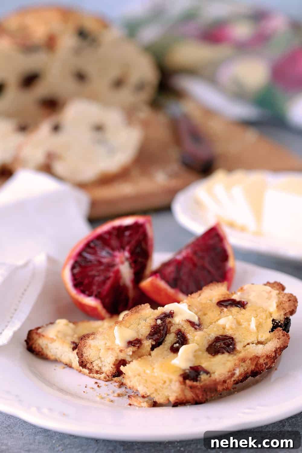 Irish Soda Bread is buttered and served on a white plate with blood orange sections.