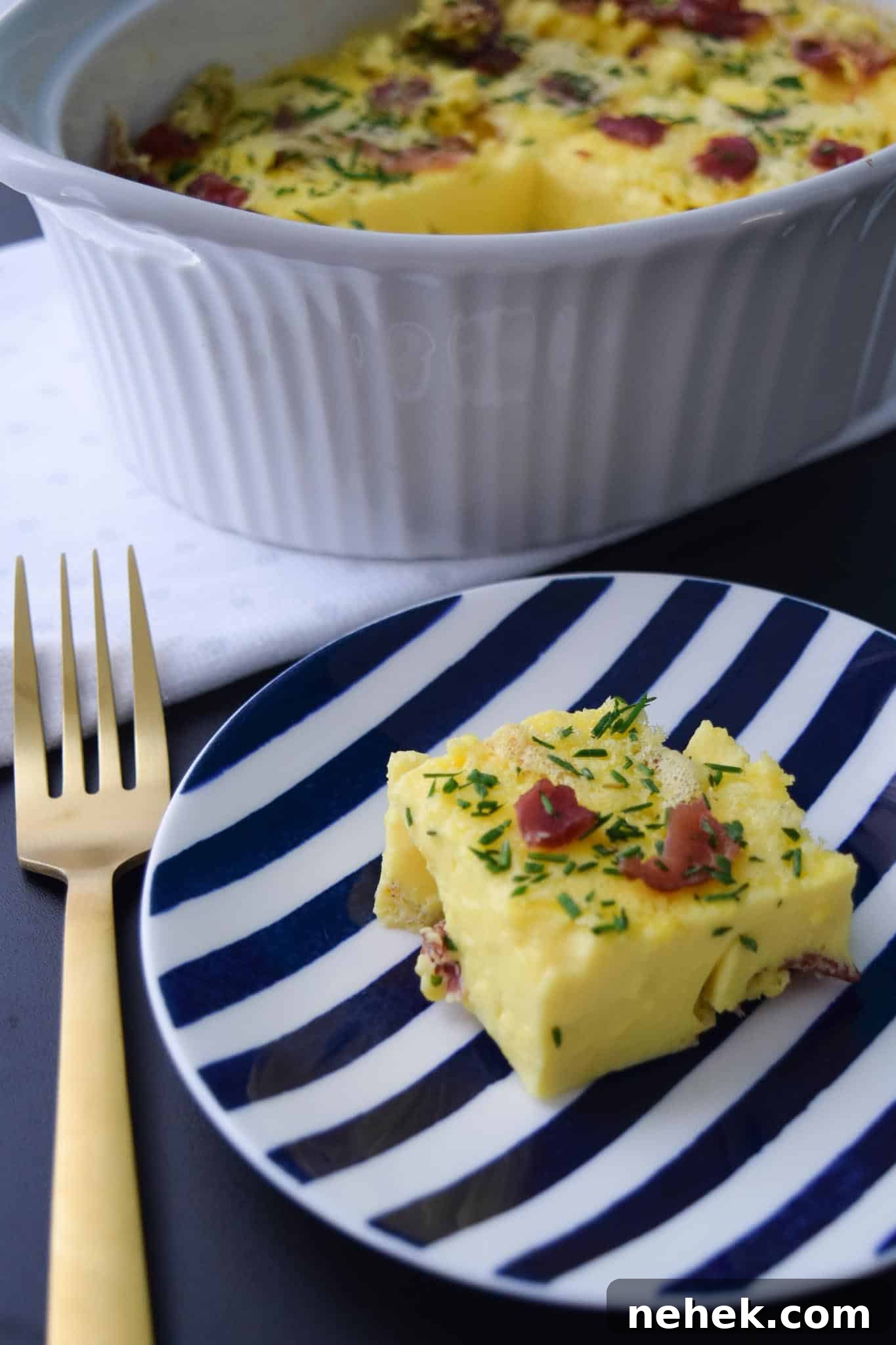 Bacon and Gruyere Breakfast Casserole Bacon and Gruyere Breakfast Casserole piece on blue and white plate ready to be served