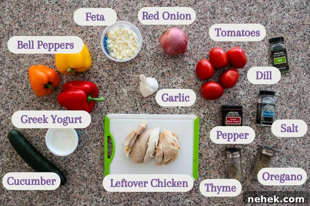 Labeled ingredients on a kitchen counter, from left to right: cucumber, greek yogurt, bell peppers, feta, leftover chicken, red onion, garlic, tomatoes, pepper, thyme, dill, salt, and oregano.
