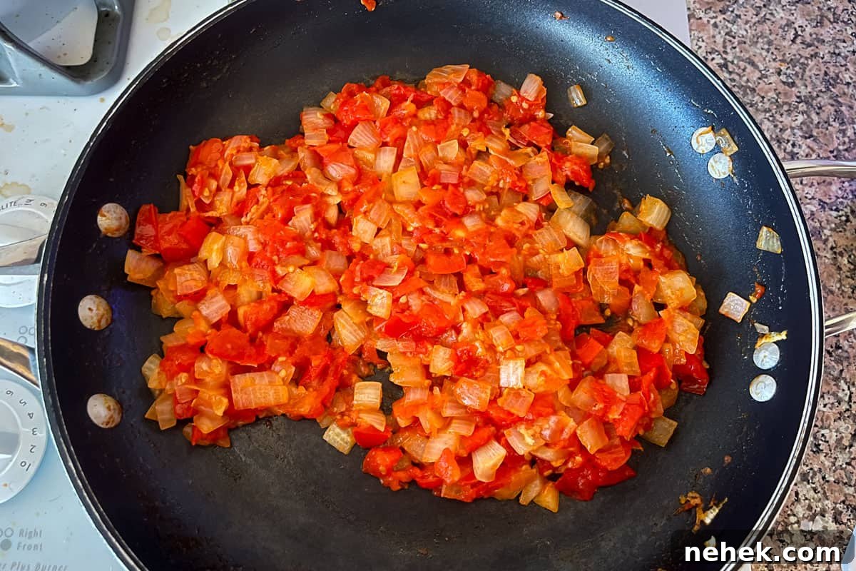 Tomatoes and onions cooked in a nonstick saute pan.