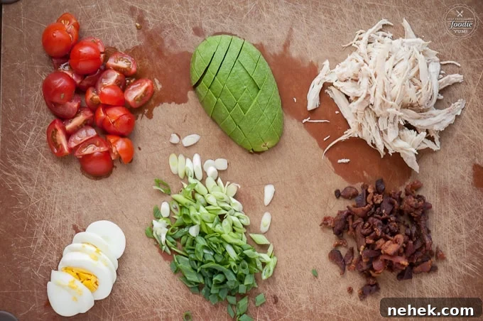 Perfect Cobb Salad has everything you want in a delicious salad including lots of greens, crisp bacon, shredded chicken, bleu cheese, hard boiled egg, ripe avocado, and tomatoes! This salad recipe is super easy to make and makes for an incredibly satisfying low carb complete meal. #cobbsalad #salad #bacon #chicken #greens #bluecheese #avocado #tomato #egg #hardboiledegg Perfect Cobb including tomato, hard boiled egg, avocado, green onion, chicken, bacon