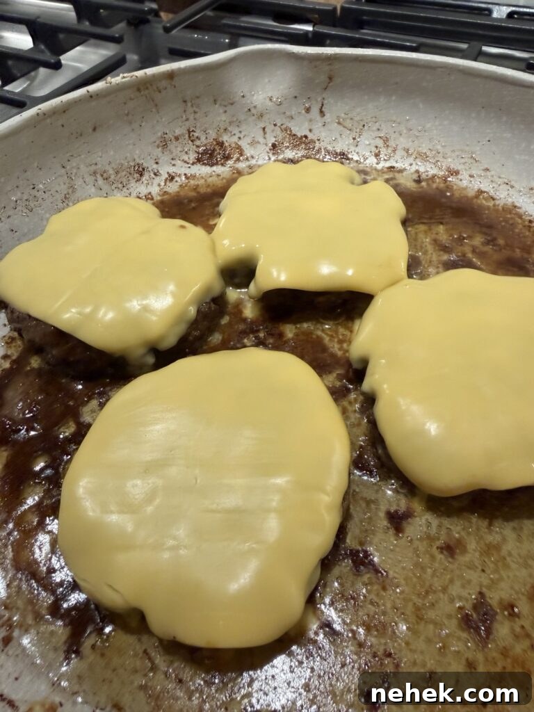 Cheese melted on patties in the pan