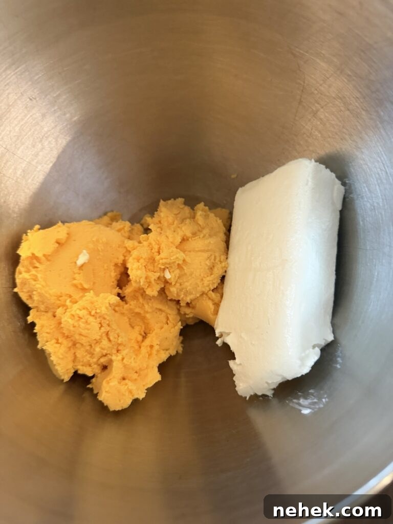 A yellow cheese and a white cheese in a metal bowl