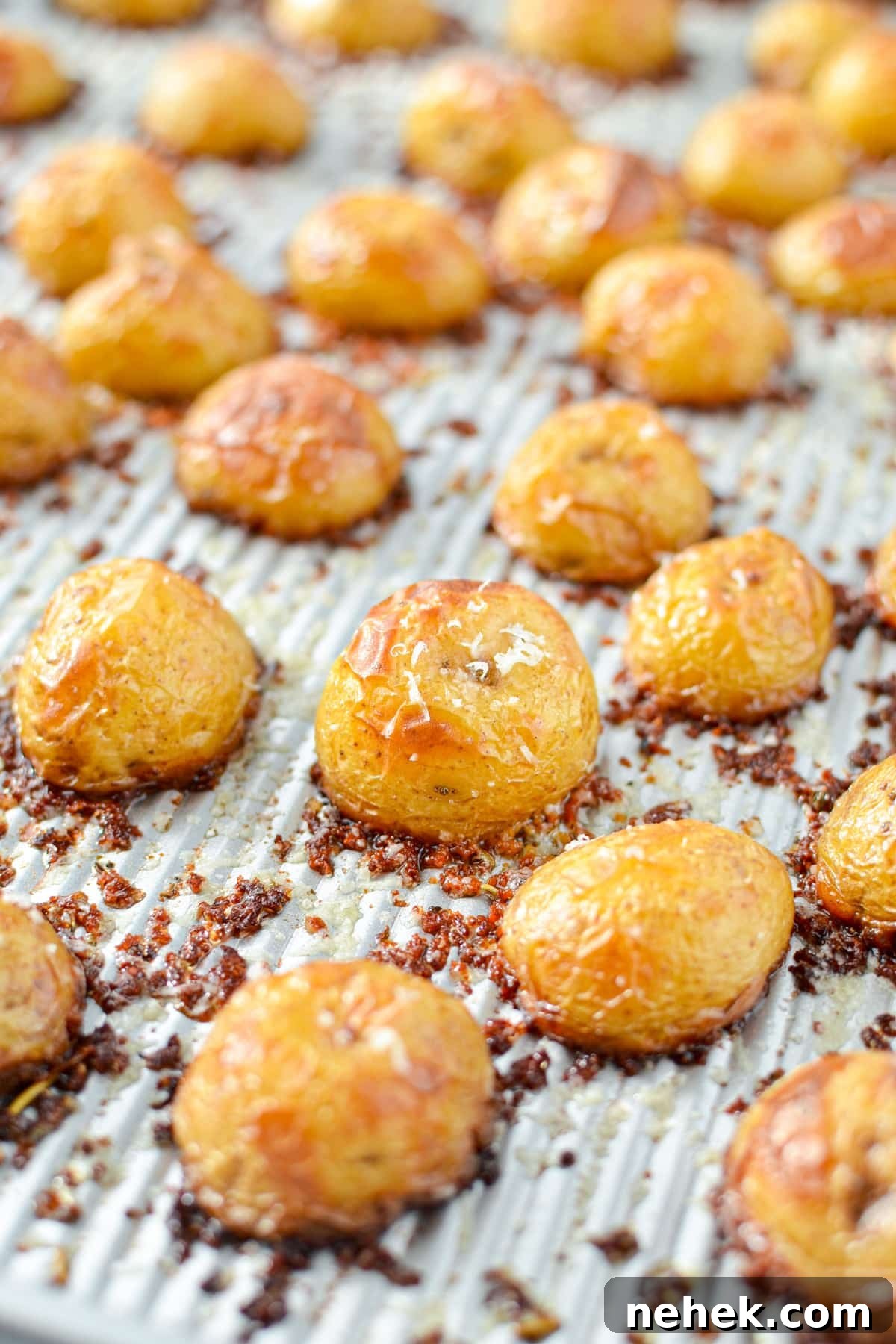 A baking sheet with potatoes crusted in parmesan cheese.