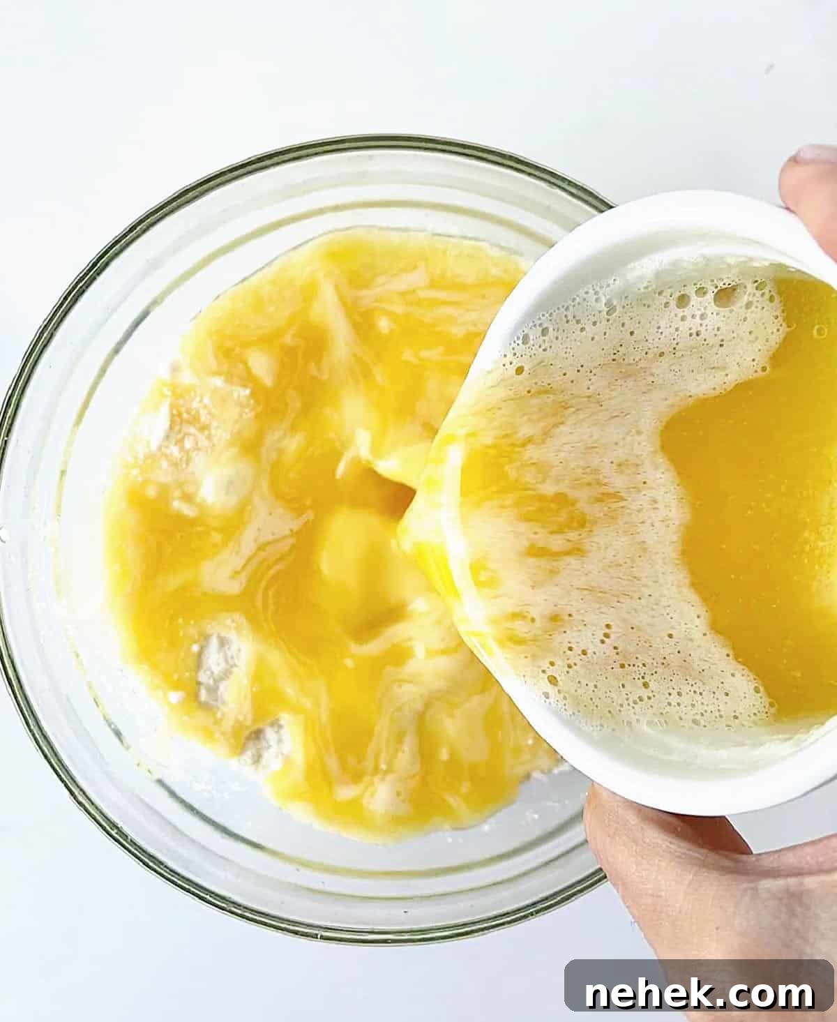 Dump cake topping mixture in glass bowl an a white surface.