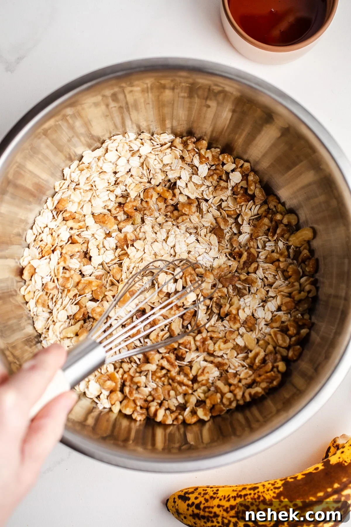 Oats and walnuts in a mixing bowl. 