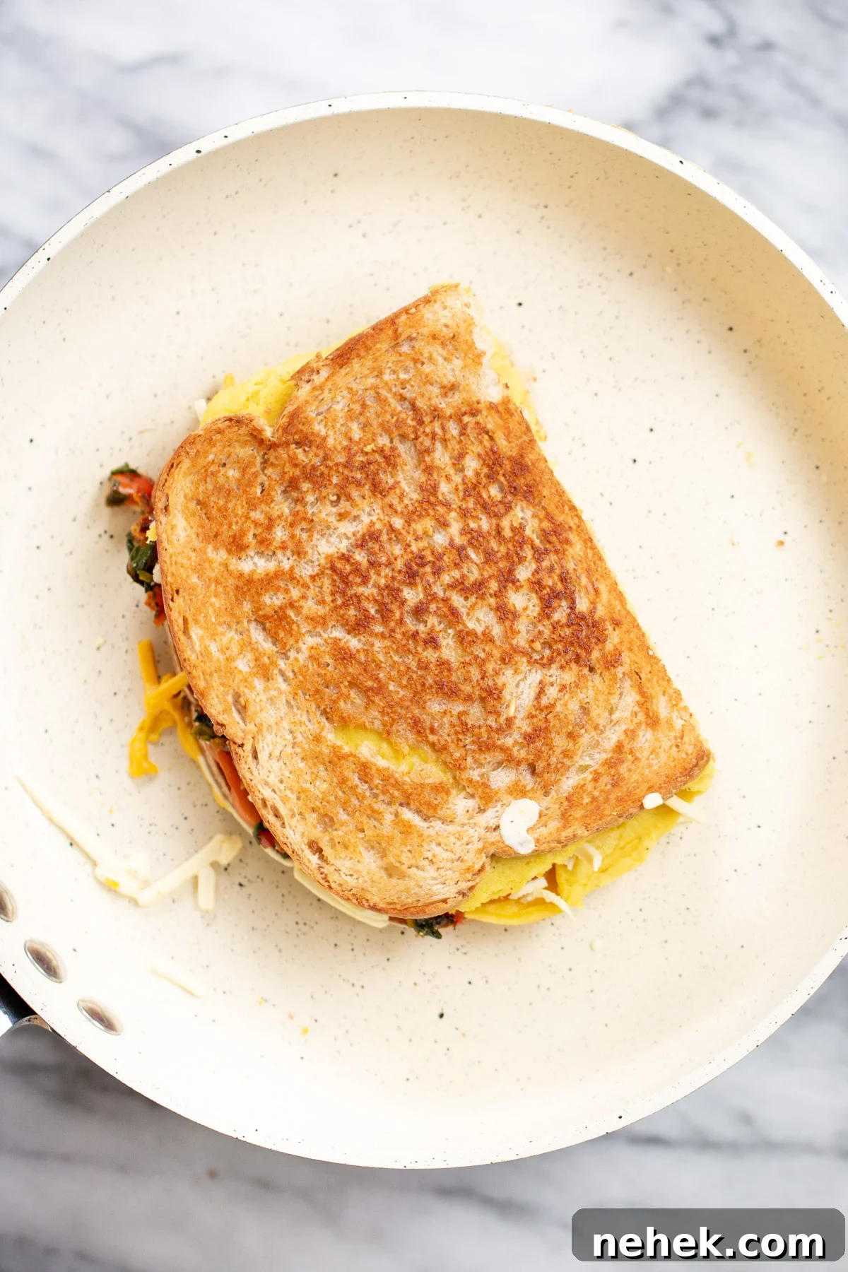 Vegan Moong Egg Sandwich Recipe: Protein-Packed Plant-Based Breakfast 11 freshly cooked vegan fold over egg sandwich in white pan