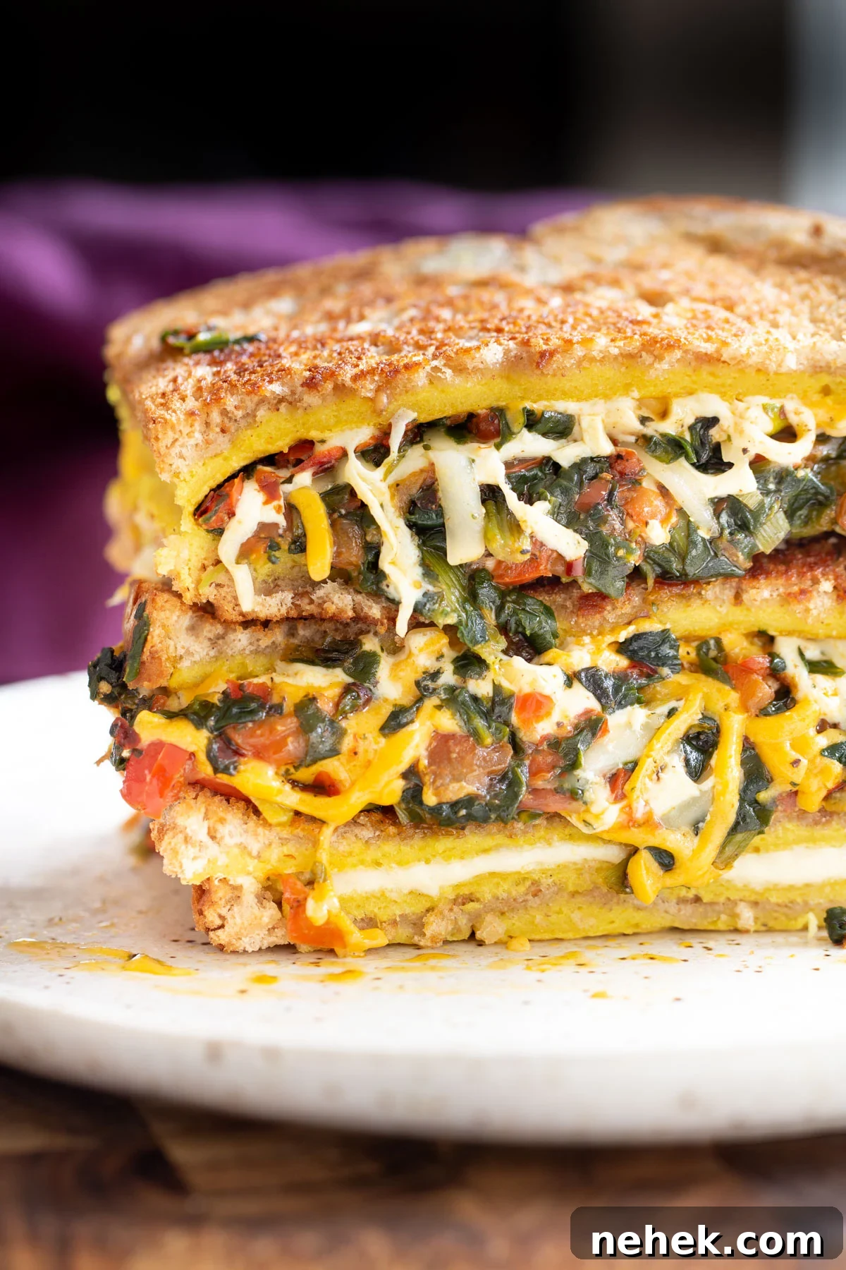 Vegan Moong Egg Sandwich Recipe: Protein-Packed Plant-Based Breakfast 3 filled spinach and cheese vegan egg sandwiches stacked on a plate