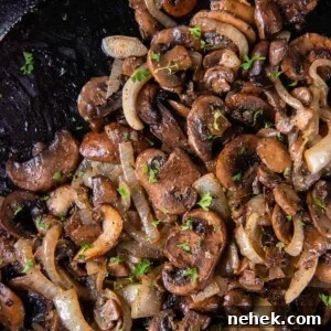 Sauteed mushrooms and onions in a black cast iron skillet after cooking.