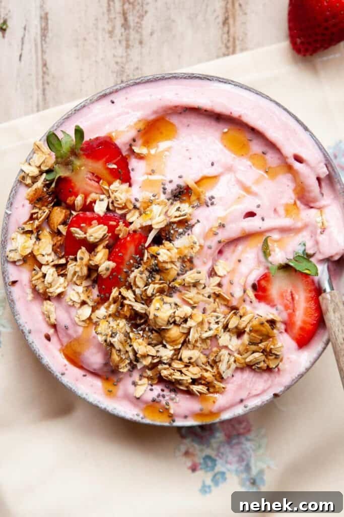 Creamy Strawberry Smoothie Bowl Recipe with Fresh Toppings 2 high protein strawberry smoothie bowl topped with granola, honey drizzle, chia seeds, and fresh strawberries