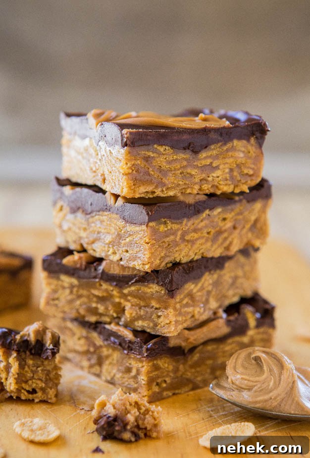 A stack of chocolate peanut butter bars on a wooden surface.