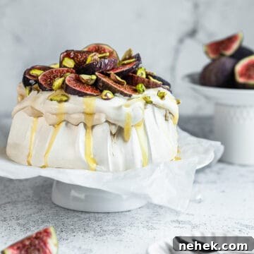 Fig and cinnamon Pavlova on a cake stand lined with parchment paper.