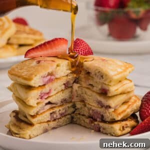 A stack of pancakes cut to show texture with syrup poured on top.