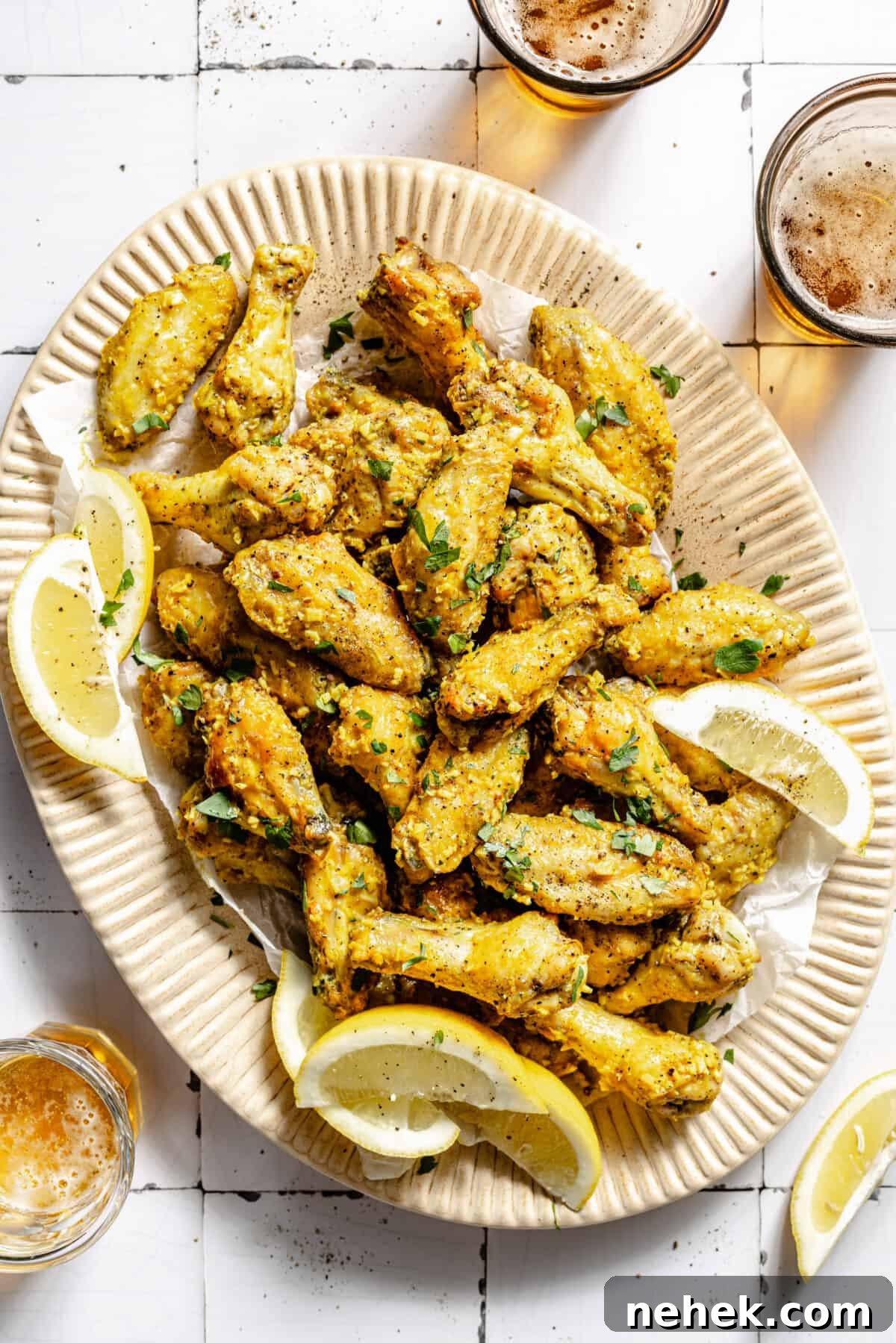 Lemon Pepper Baked Chicken Wings on platter. Lemon wedges on platter.