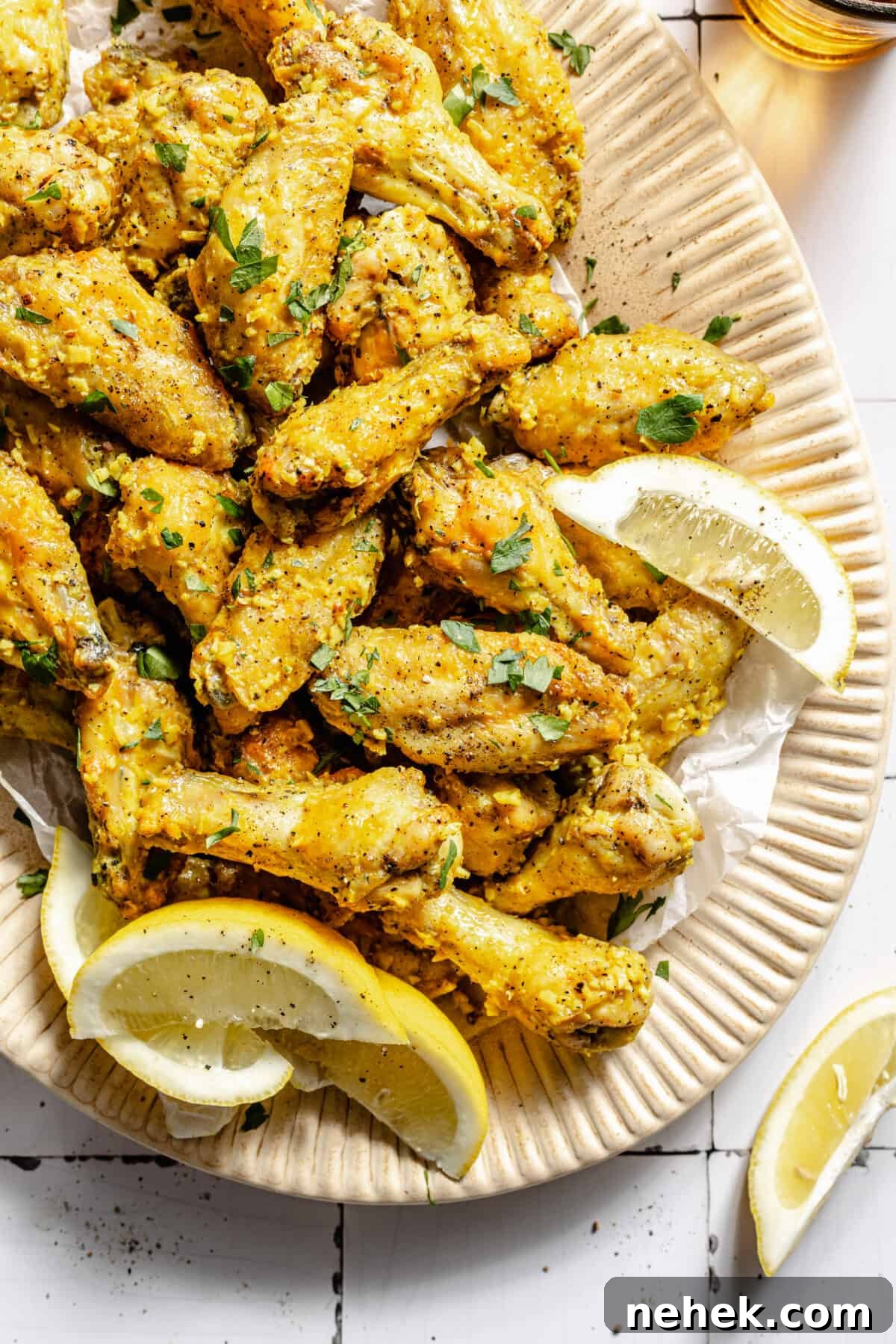 Lemon Pepper Baked Chicken Wings on platter with lemon wedges.
