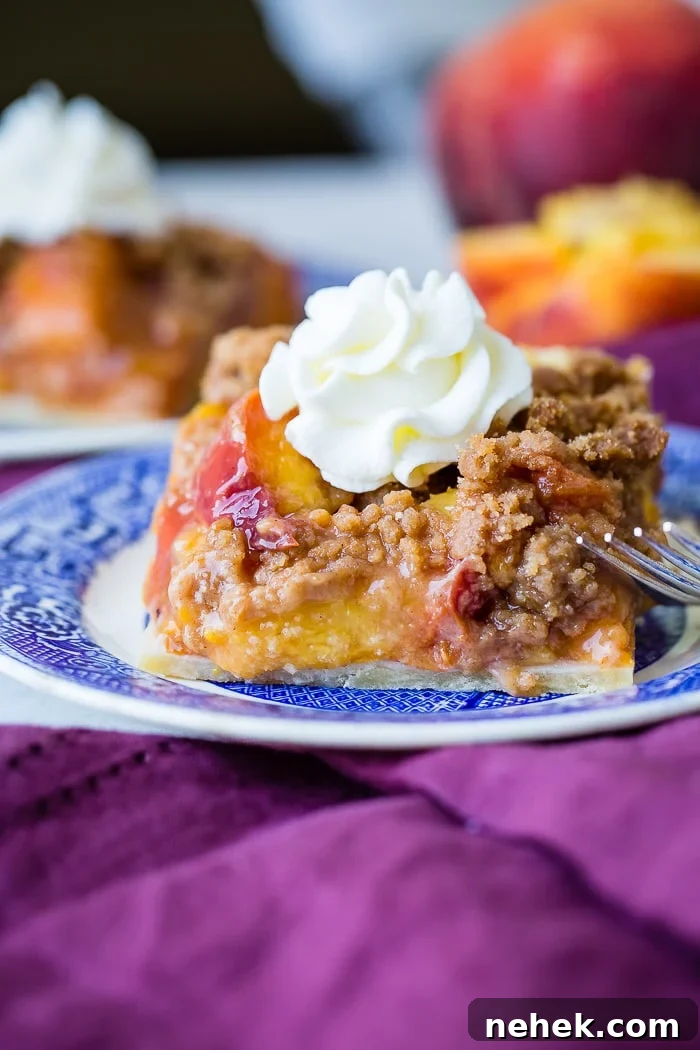 Brown Sugar Peach Pie Bars Recipe — Sticky Peach Dessert Bars 4 A purple napkin under a vibrant blue china designed dessert plate with a slice of brown sugar peach pie bars