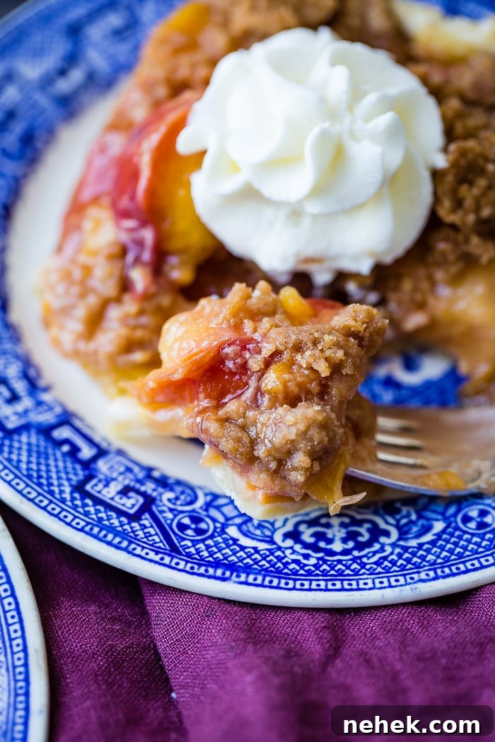 Brown Sugar Peach Pie Bars Recipe — Sticky Peach Dessert Bars 7 A purple napkin under a vibrant blue china designed dessert plate with a slice of brown sugar peach pie bars
