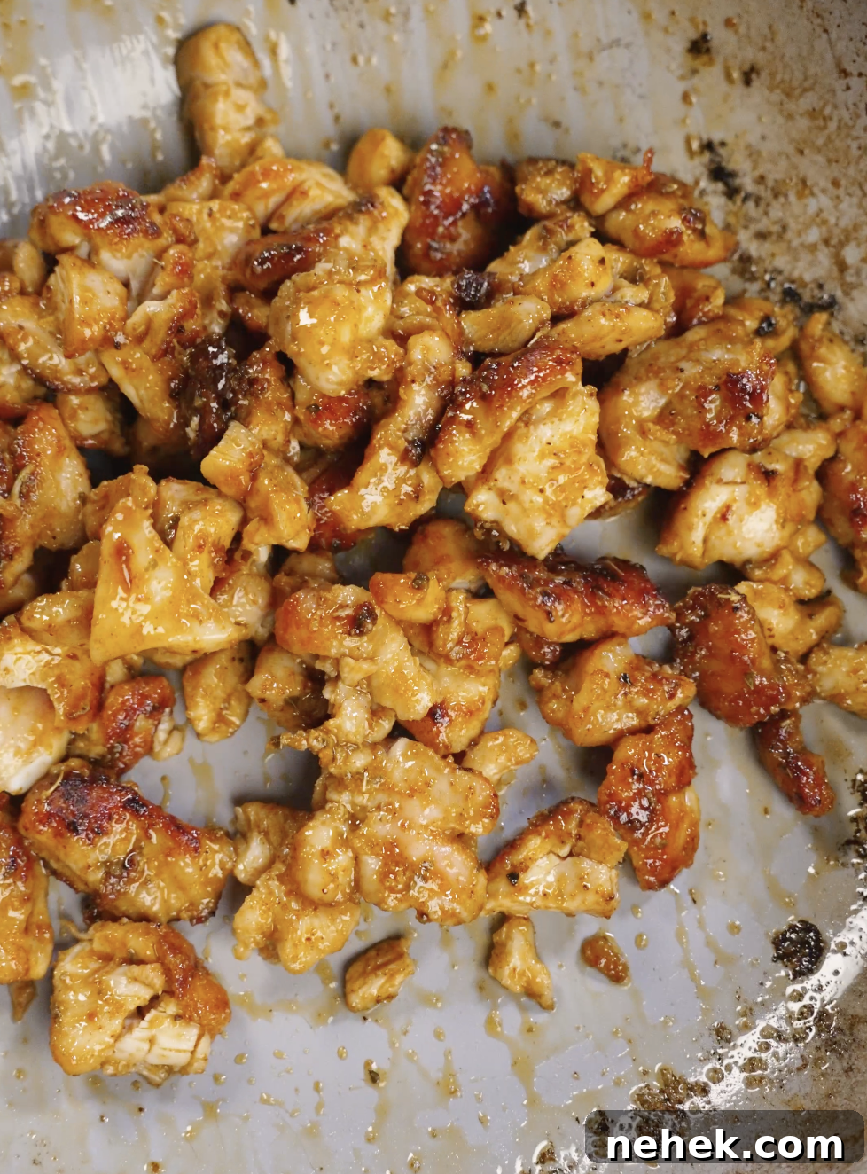 Seasoned chicken thigh pieces cooking in a hot skillet until golden brown and caramelized, developing crispy edges for homemade crispy chicken tacos.