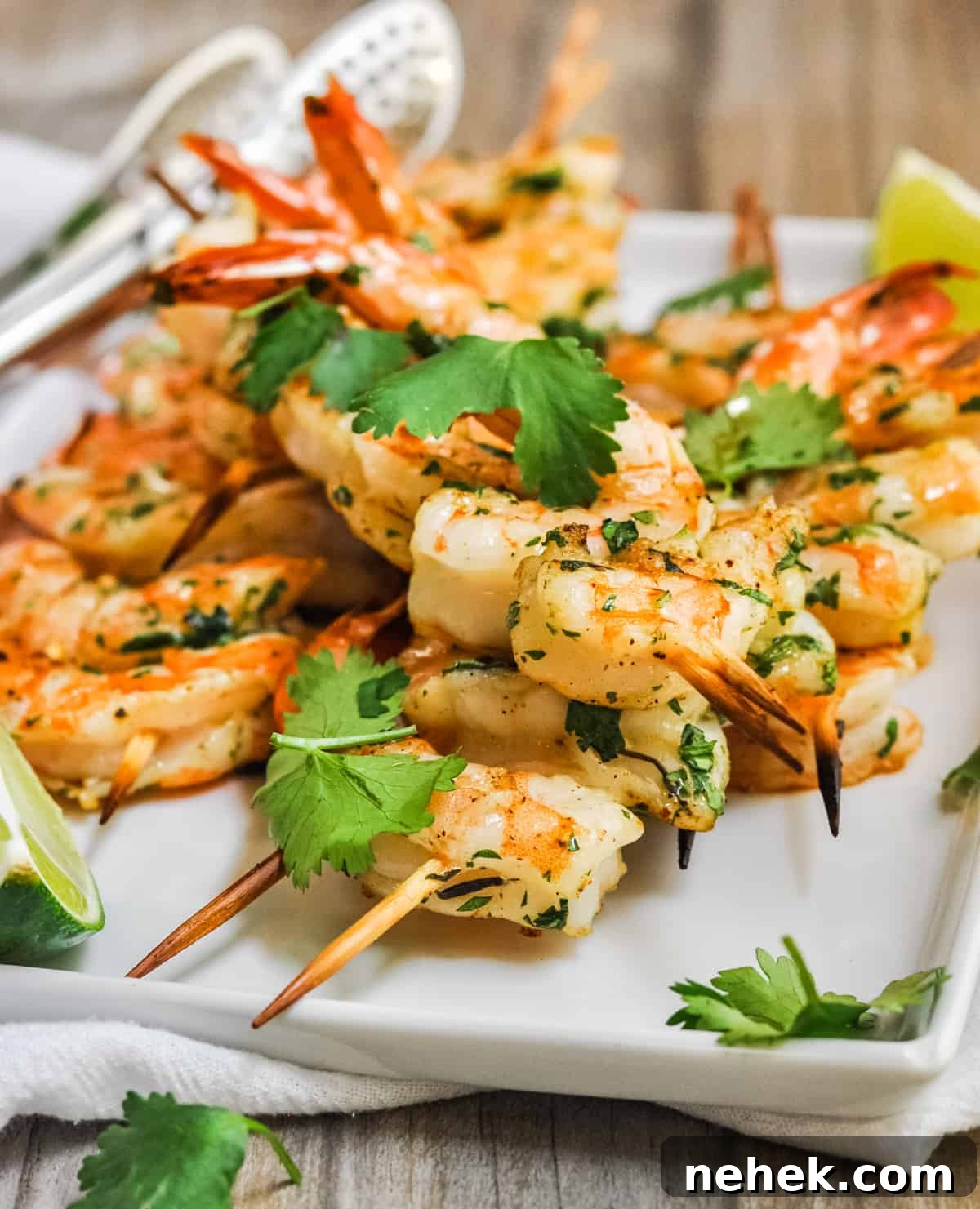 Spicy Grilled Shrimp Recipe with Cajun Marinade and Garlic Butter 2 Spicy Grilled Shrimp served on a white platter with lime wedges.