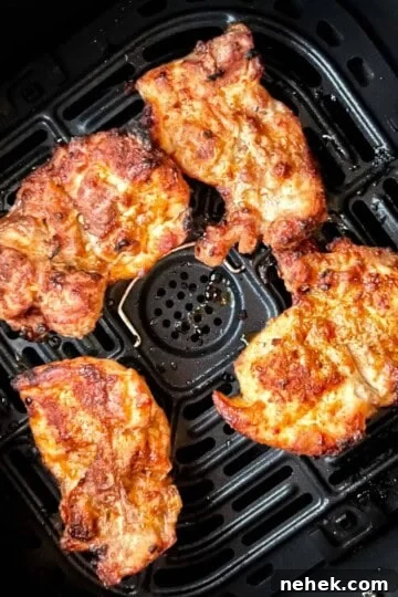 Perfectly cooked air fryer boneless thighs in the air fryer basket.