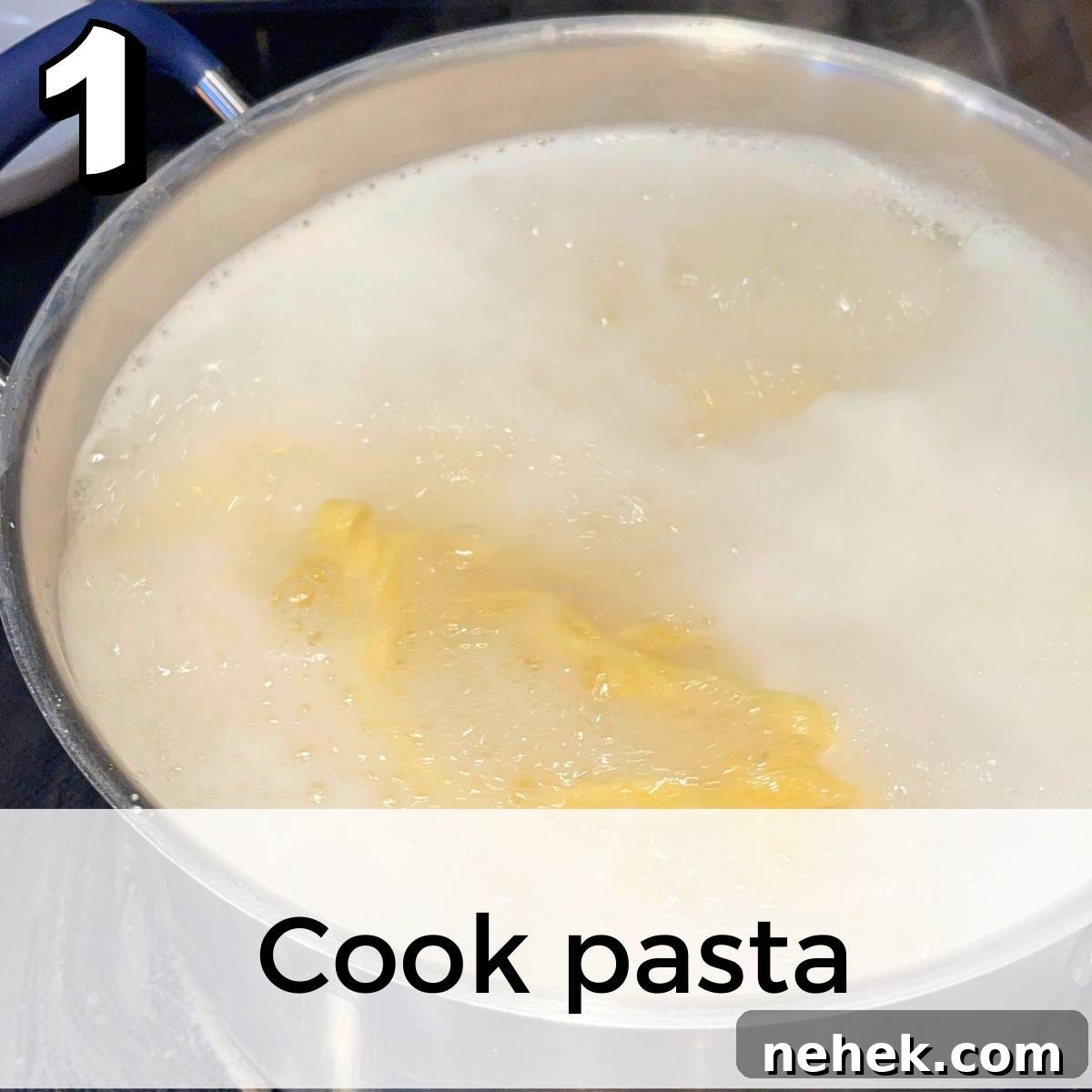 The fettuccine noodles boiling in a large pot of salted water on the stove.