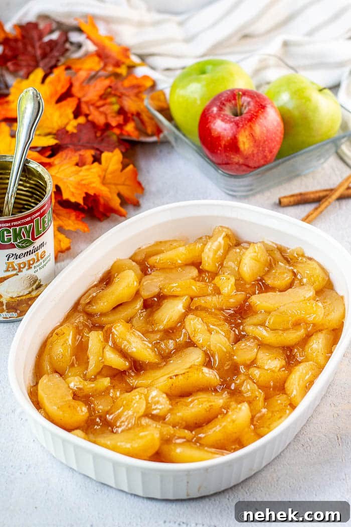 Caramel Apple Dump Cake Recipe with Homemade Sauce 4 White baking dish filled with 2 cans of apple pie filling that has been combined with cinnamon.