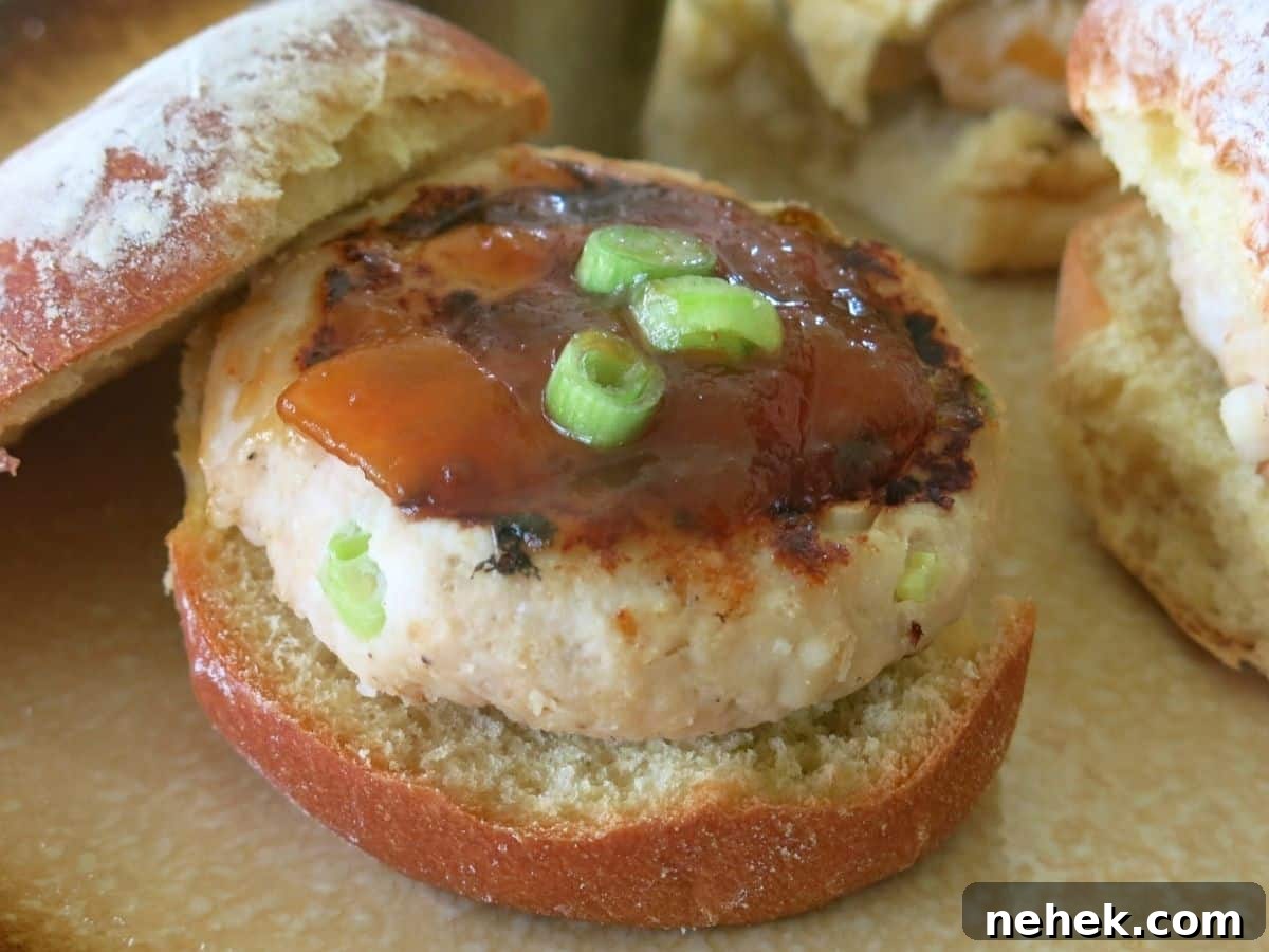 Mango turkey burger on a bun with the top leaning on the side.