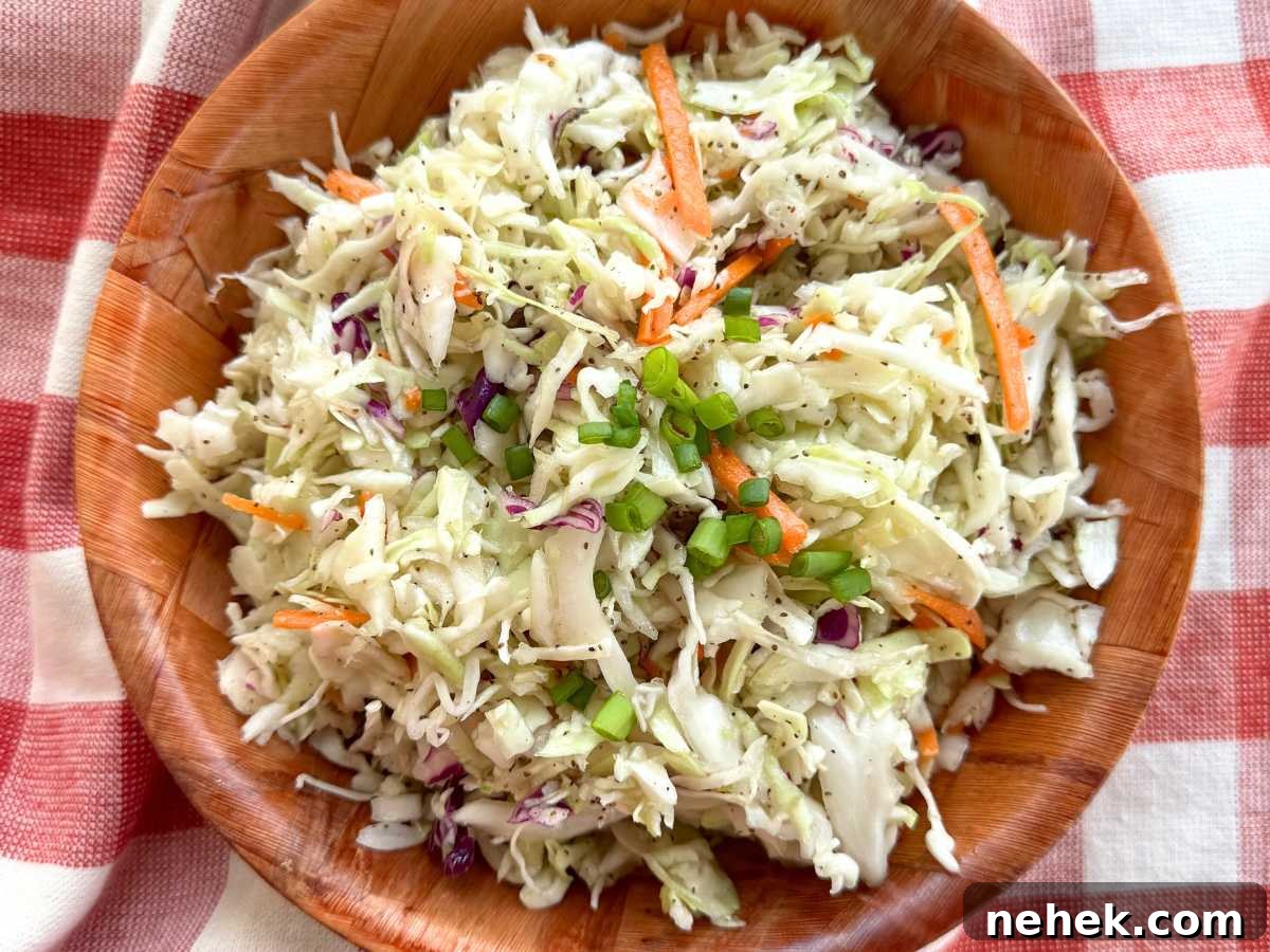Southern vinegar coleslaw in a brown bowl on a red checkered napkin.