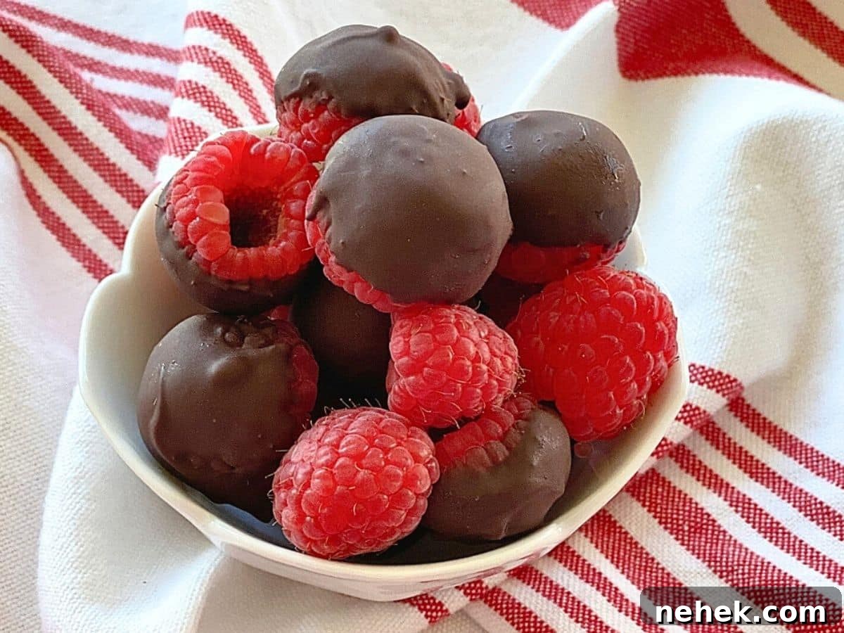 White bowl of chocolate covered raspberries.
