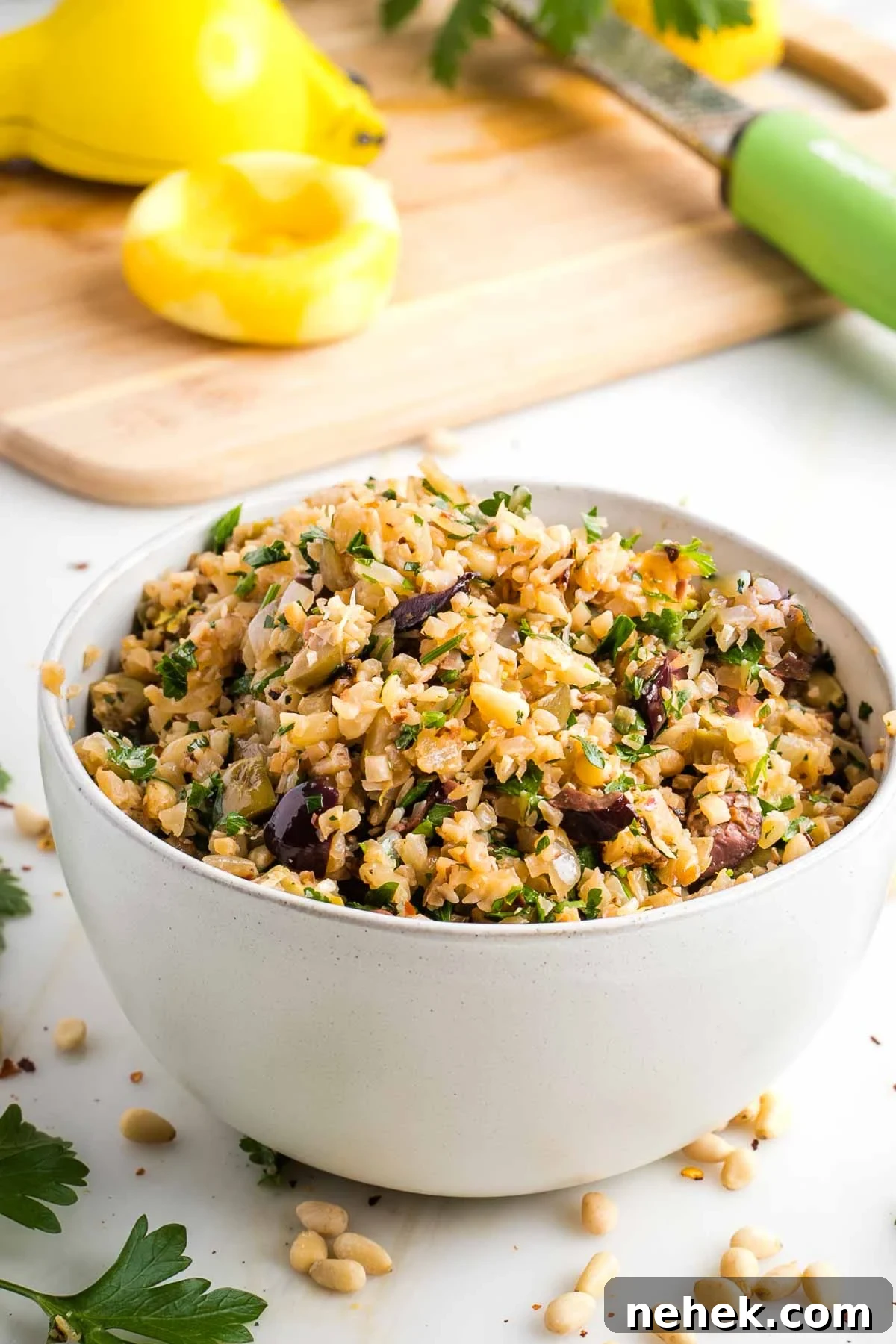 Mediterranean Cauliflower Rice Recipe with Sun‑Dried Tomatoes & Olives 2 Cauliflower Rice with olives, pine nuts and fresh parsley, with lemon in the background.