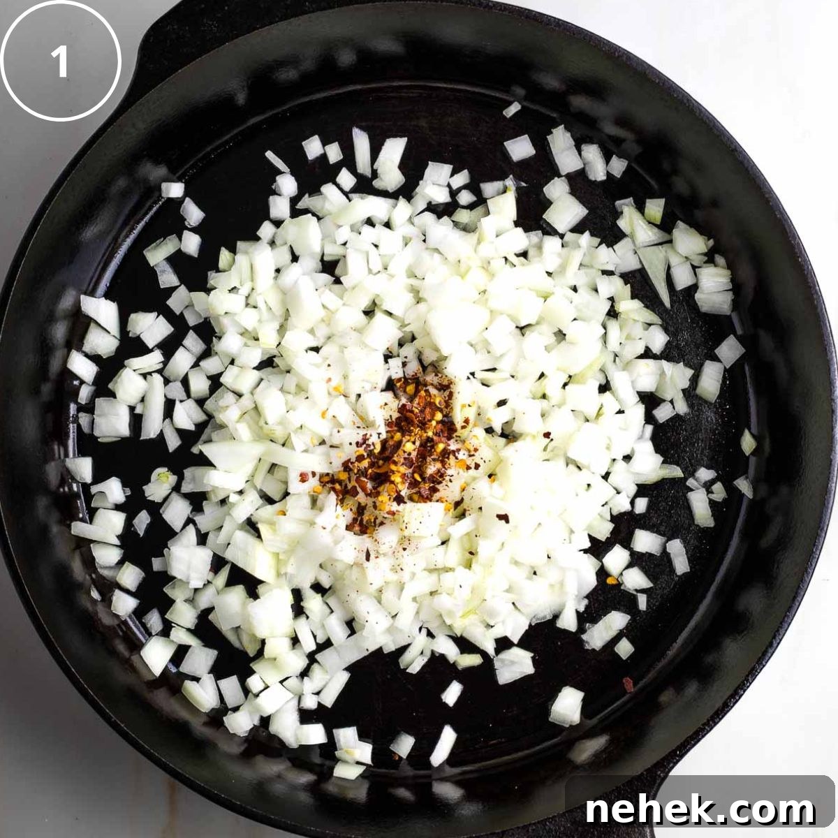 Mediterranean Cauliflower Rice Recipe with Sun‑Dried Tomatoes & Olives 4 Step 1: Cast iron skillet with diced onions and crushed red pepper.