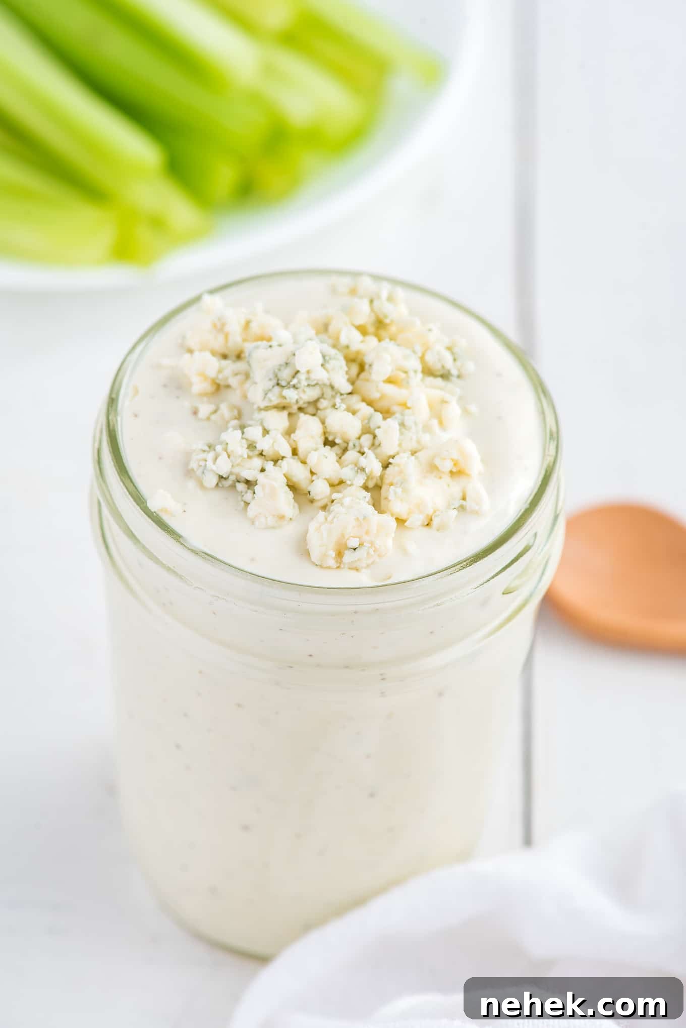 A jar of easy blue cheese dressing with crumbles on top.