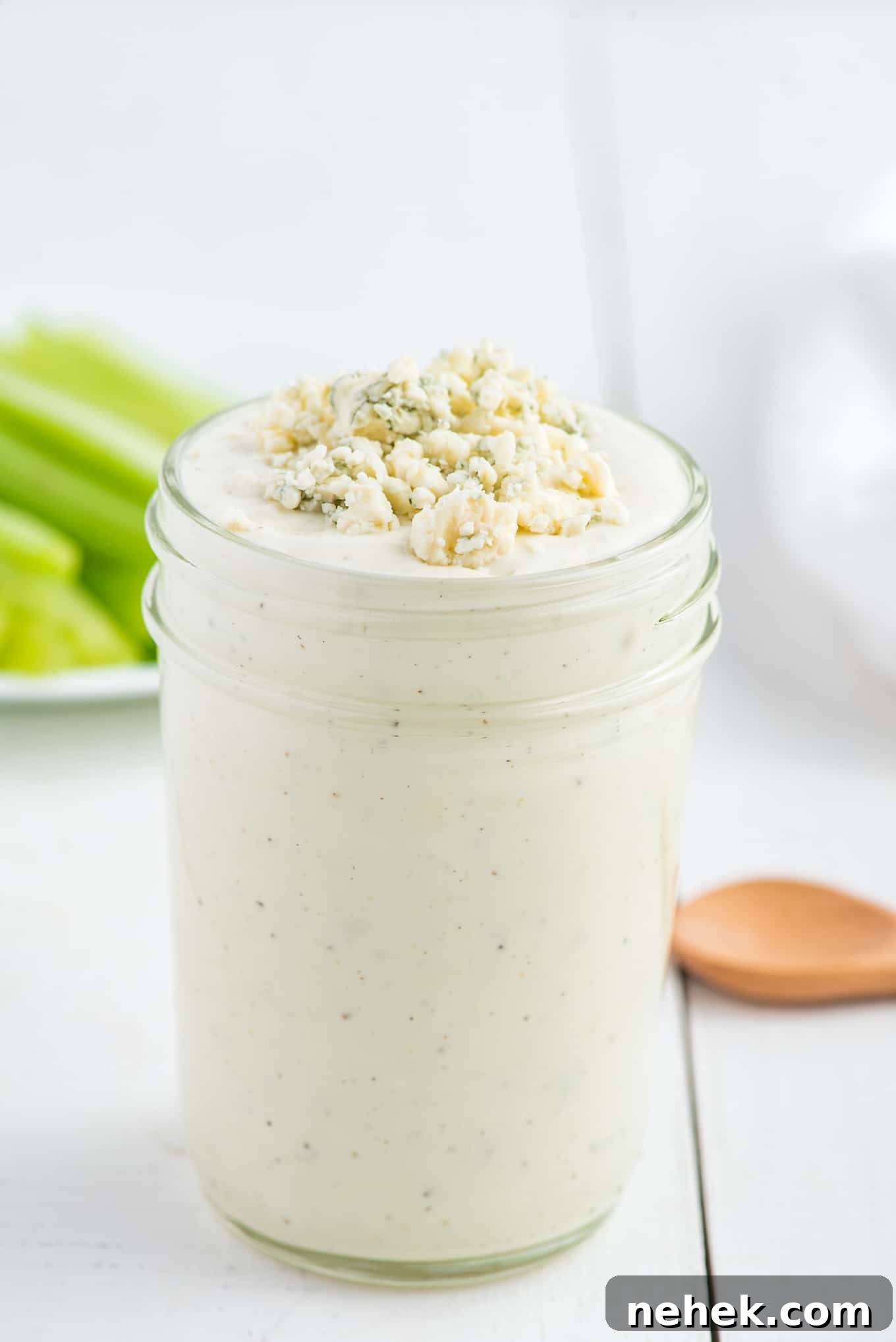 Dressing in a glass jar with blue cheese crumbles on top.