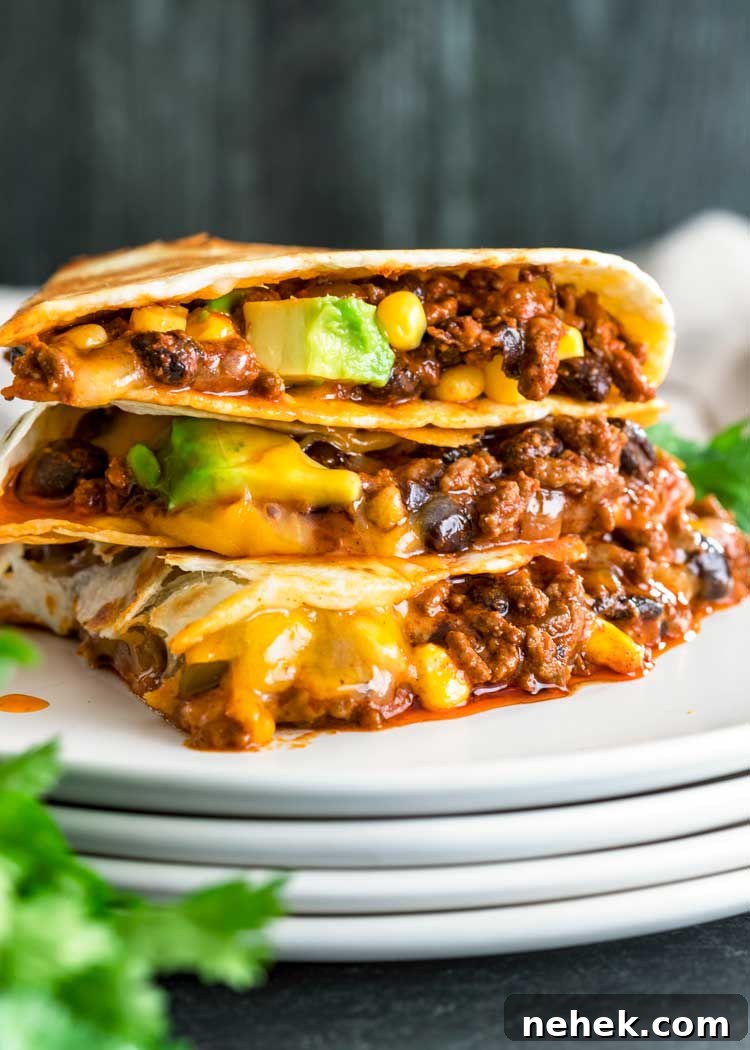 My Crispy Ground Beef Quesadillas are filled with melted Queso quesadilla, cheddar or Monterey Jack cheese, seasoned ground beef, avocado, beans and corn. stack of sliced Crispy Ground Beef Quesadillas