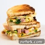How to Make a Classic Western Sandwich (Ham, Egg & Peppers) 13 a side view of two halves of a western sandwich stacked on each other.