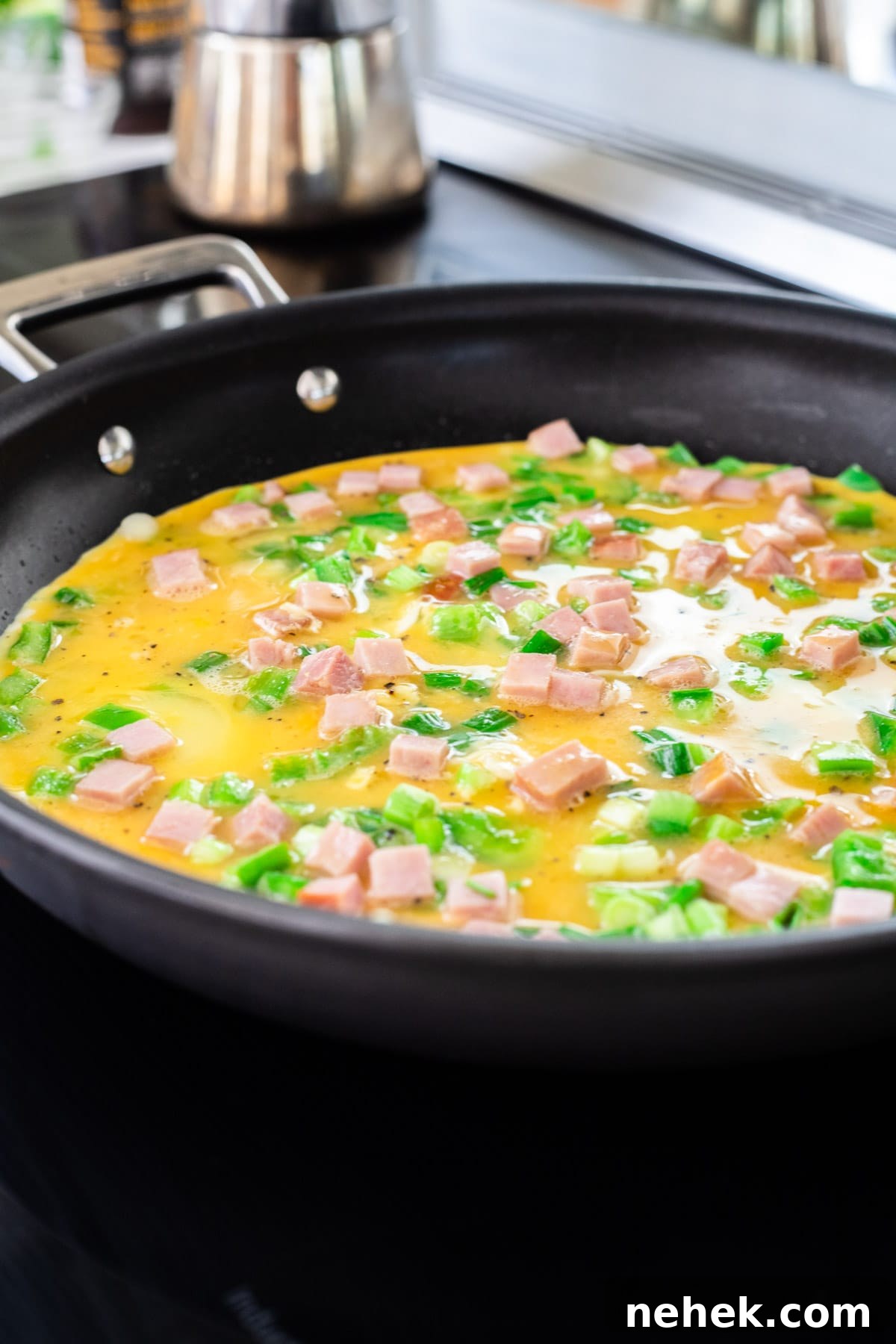 How to Make a Classic Western Sandwich (Ham, Egg & Peppers) 6 A Western omelette cooking in a skillet.
