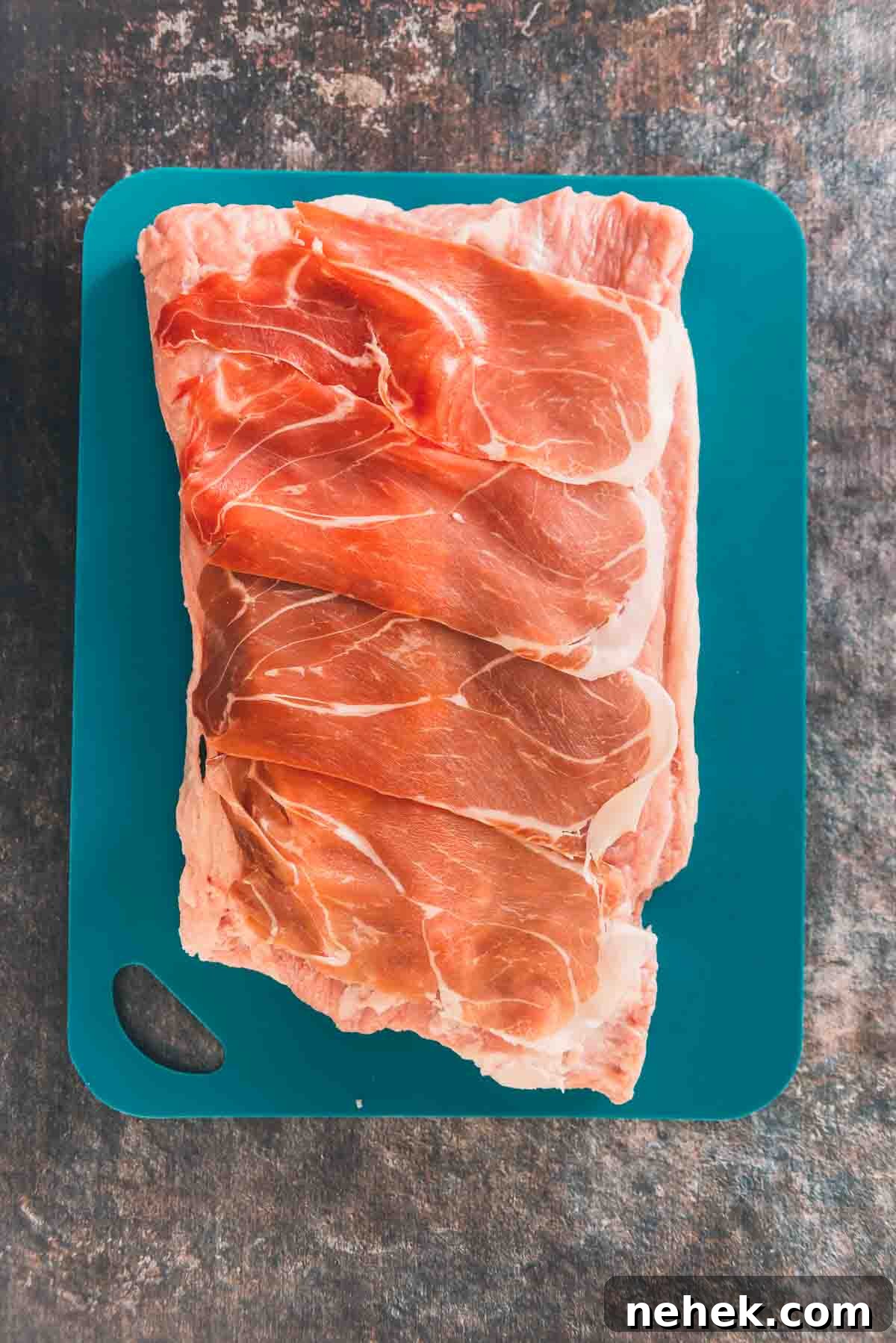 Layers of prosciutto over the meat.