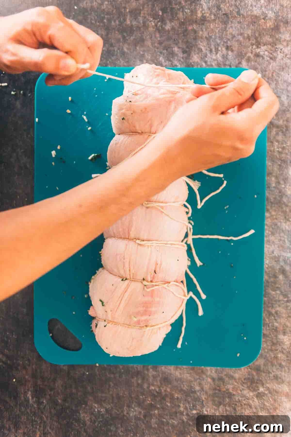 Hands tieing the veal to secure.