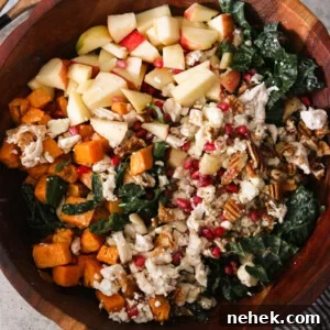 an overhead shot of a fall harvest salad in a wooden bowl