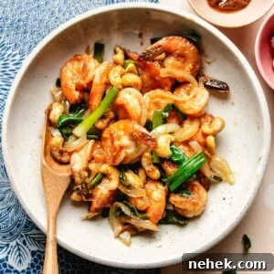 Recipe image for shacha shrimp served on a white plate with a spoon on the side.