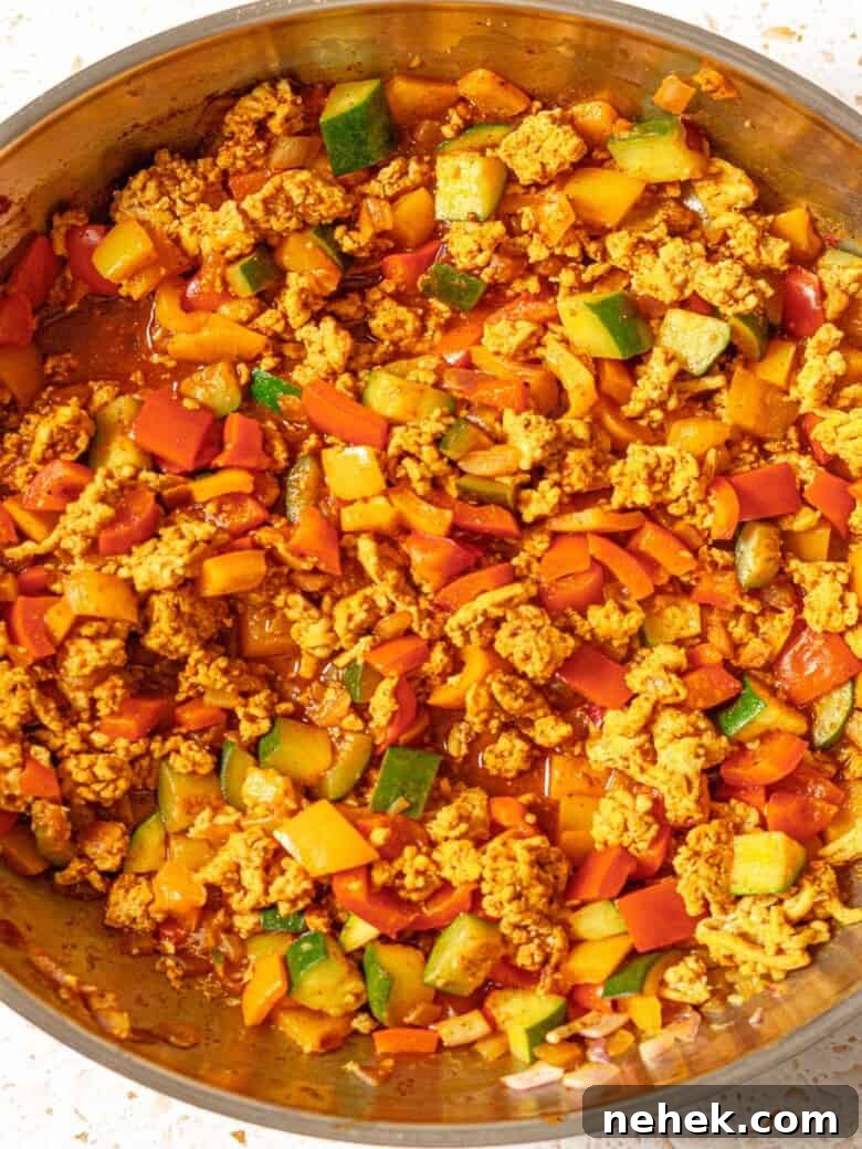 Vegetables and ground turkey cooked in a stainless steel skillet.