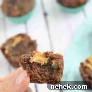 35 High-Protein Vegan Powder Recipes for Smoothies & Snacks 19 Two fingers placing a brownie on top of more chocolate protein brownies.