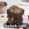 35 High-Protein Vegan Powder Recipes for Smoothies & Snacks 20 Three chocolate protein brownies stacked.