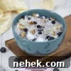 35 High-Protein Vegan Powder Recipes for Smoothies & Snacks 28 Protein oatmeal with blueberries and pecans in a blue bowl.